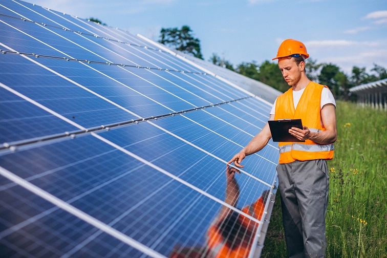 Man worker in the firld by the solar panels